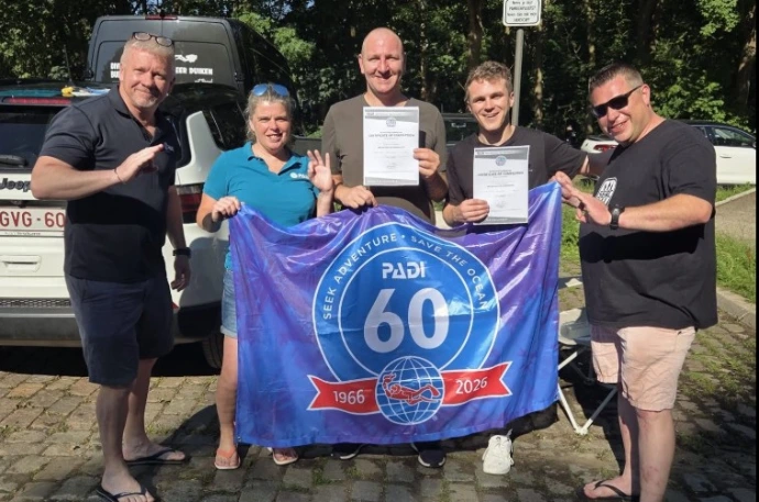 Dive Pro Group-team met PADI 60-jarig jubileumvlag