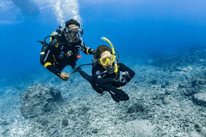 Instructor-kandidaat begeleidt duiker tijdens openwater teaching practice