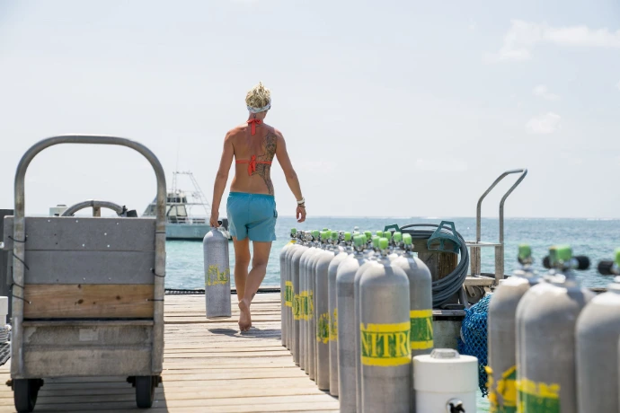 Duiker maakt de nitrox fles klaar om te gaan duiken
